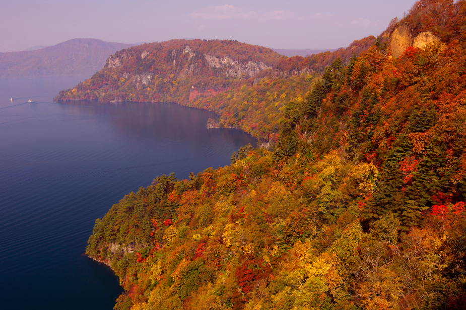 十和田湖周辺の紅葉風景を示す画像