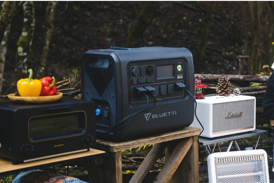 キャンプ場で使用されているポータブル電源。周囲にキャンプ道具や照明がある